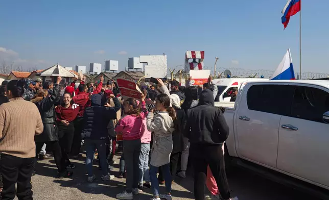 FILE - Members of the Alawite minority gather outside the Russian air base in Hmeimim, near Latakia in Syria's coastal region, March 11, 2025, as they seek refuge there after recent violence and retaliatory killings in the area. (AP Photo/Omar Albam, File)