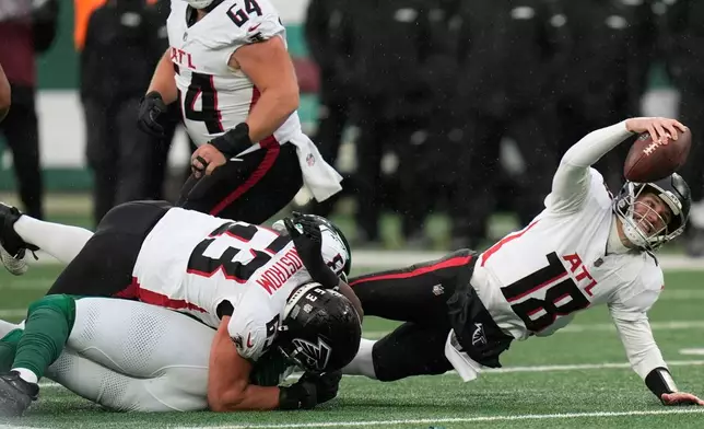 Atlanta Falcons quarterback Kirk Cousins (18) is tackled against the New York Jets during the first half of an NFL football game, Sunday, Nov. 30, 2025, in East Rutherford, N.J. (AP Photo/Seth Wenig)