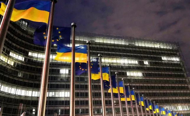 FILE - The European Union and Ukrainian flags flap in the wind to mark the third anniversary of Russia's full-scale invasion of Ukraine outside EU headquarters in Brussels, Feb. 24, 2025. (AP Photo/Virginia Mayo, File)