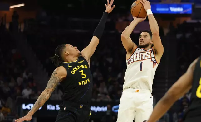 Phoenix Suns guard Devin Booker (1) looks to shoot against Golden State Warriors guard Will Richard (3) during the first half of an NBA basketball game in San Francisco, Saturday, Dec. 20, 2025. (AP Photo/Jed Jacobsohn)