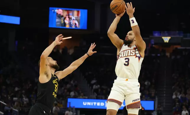 Phoenix Suns forward Dillon Brooks (3) looks to shoot against Golden State Warriors guard Stephen Curry, left, during the first half of an NBA basketball game in San Francisco, Saturday, Dec. 20, 2025. (AP Photo/Jed Jacobsohn)