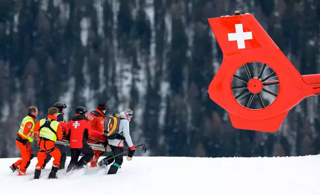 Michelle Gisin of Switzerland is being carried on a stretcher to a helicopter after a fall, during the women's Downhill training race at the Alpine Skiing FIS Ski World Cup, in St. Moritz, Switzerland, Thursday, Dec. 11, 2025. (Jean-Christophe Bott/Keystone via AP)