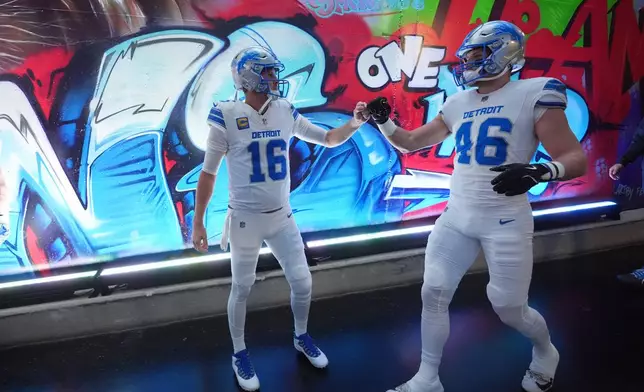 Detroit Lions quarterback Jared Goff (16) and linebacker Jack Campbell bump fists prior to an NFL football game against the Dallas Cowboys Thursday, Dec. 4, 2025, in Detroit. (AP Photo/Paul Sancya)