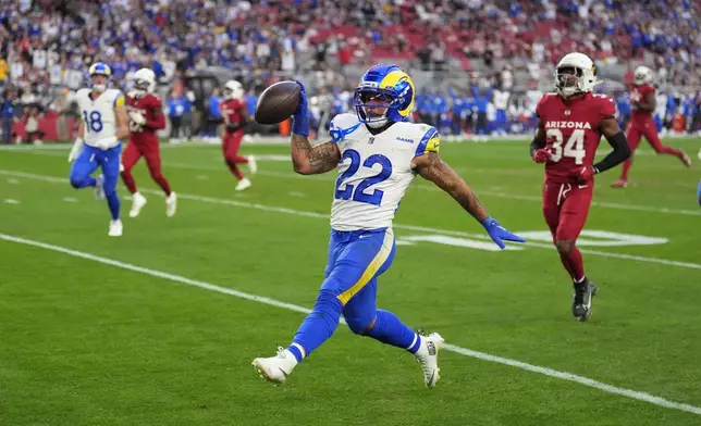 Los Angeles Rams running back Blake Corum (22) celebrates after his long run for a touchdown as Arizona Cardinals safety Jalen Thompson (34) pursues in the second half of an NFL football game Sunday, Dec. 7, 2025, in Glendale, Ariz. (AP Photo/Ross D. Franklin)