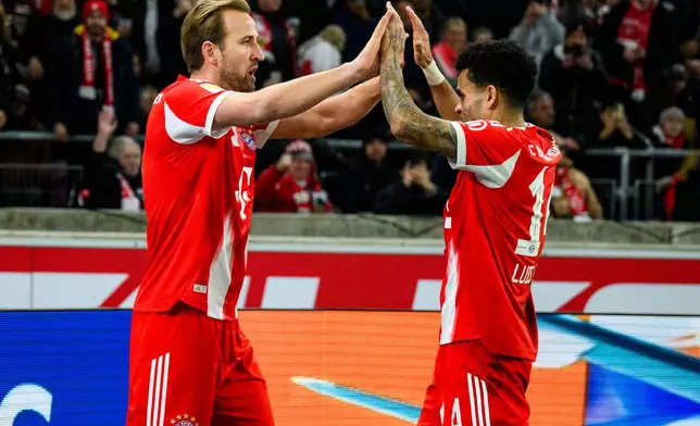 Munich's Harry Kane, left, celebrates with his teammate Luis Diaz, right, after scoring his side's second goal during the German Bundesliga soccer match between VfB Stuttgart and FC Bayern Munich in Stuttgart, Germany, Saturday, Dec. 6, 2025. (Tom Weller/dpa via AP)