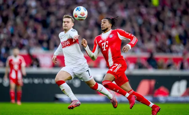 Munich's Michael Olise, right, and Stuttgart's Maximilian Mittelstaedt, left, challenge for the ball during the German Bundesliga soccer match between VfB Stuttgart and FC Bayern Munich in Stuttgart, Germany, Saturday, Dec. 6, 2025. (Tom Weller/dpa via AP)