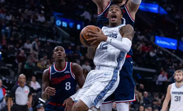 Memphis Grizzlies guard Ja Morant (12) lays up the ball up against Los Angeles Clippers center Ivica Zubac, top, during the first half of an NBA basketball game Monday, Dec. 15, 2025, in Inglewood, Calif. (AP Photo/Ethan Swope)