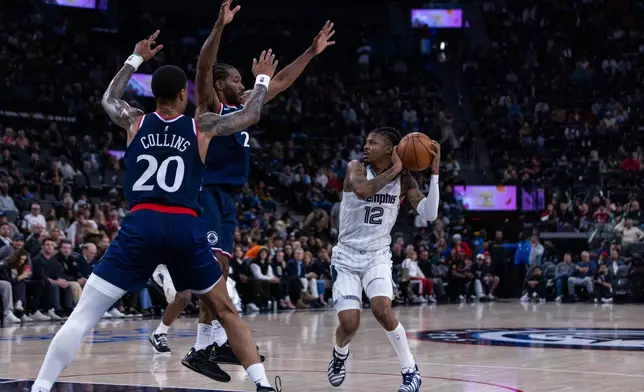 Memphis Grizzlies guard Ja Morant (12) is defended by Los Angeles Clippers players during the first half of an NBA basketball game Monday, Dec. 15, 2025, in Inglewood, Calif. (AP Photo/Ethan Swope)