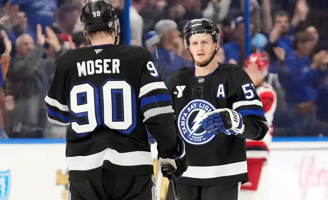 Tampa Bay Lightning center Jake Guentzel (59) celebrates his goal against the Carolina Hurricanes with defenseman J.J. Moser (90) during the third period of an NHL hockey game Saturday, Dec. 20, 2025, in Tampa, Fla. (AP Photo/Chris O'Meara)