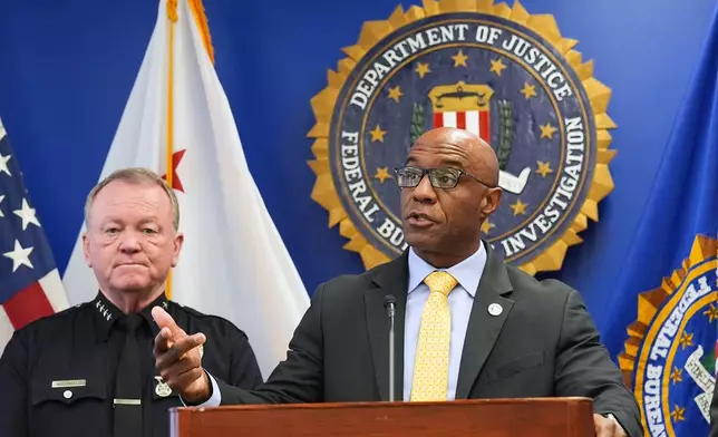 FBI Assistant Director in Charge Akil Davis, right, speaks in front of LAPD Chief Jim McDonnell while announcing developments on a terrorism investigation during a press conference Monday, Dec. 15, 2025, in Los Angeles. (AP Photo/Damian Dovarganes)