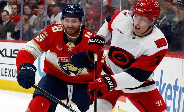 Carolina Hurricanes' Taylor Hall (71) clears the puck in front of Florida Panthers' Noah Gregor (18) during the first period of an NHL hockey game in Raleigh, N.C., Tuesday, Dec. 23, 2025. (AP Photo/Karl DeBlaker)
