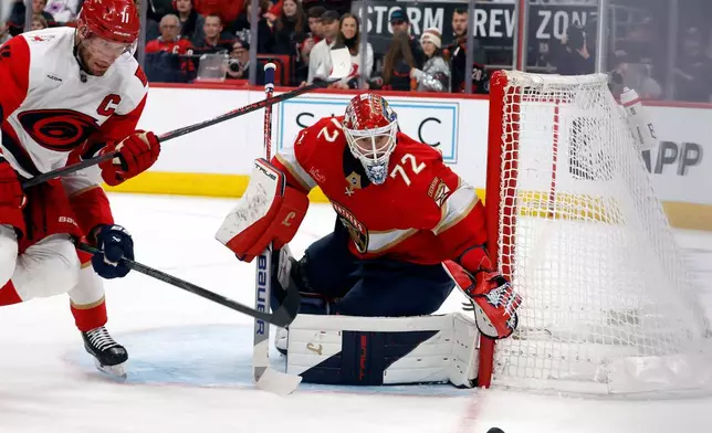 Florida Panthers goaltender Sergei Bobrovsky (72) watches the puck go by the net as Carolina Hurricanes' Jordan Staal (11) closes in during the second period of an NHL hockey game in Raleigh, N.C., Tuesday, Dec. 23, 2025. (AP Photo/Karl DeBlaker)