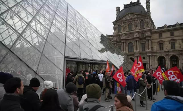 Unionists demonstrate at the entrance of the Louvre museum after employees have voted to extend a strike that has disrupted operations at the world's most visited museum, Wednesday, Dec. 17, 2025 in Paris. (AP Photo/Christophe Ena)