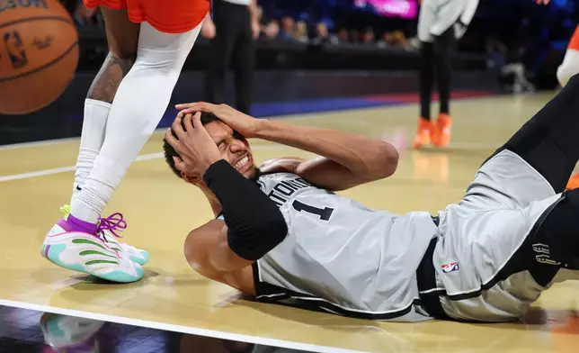 San Antonio Spurs forward Victor Wembanyama (1) lands on the court during the second half of an NBA Cup semifinals basketball game against the Oklahoma City Thunder, Saturday, Dec. 13, 2025, in Las Vegas. (AP Photo/Ronda Churchill)