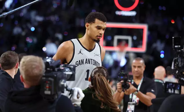 San Antonio Spurs forward Victor Wembanyama (1) stands on court before film crews after playing in an NBA Cup semifinals basketball game against the Oklahoma City Thunder, Saturday, Dec. 13, 2025, in Las Vegas. (AP Photo/Ronda Churchill)