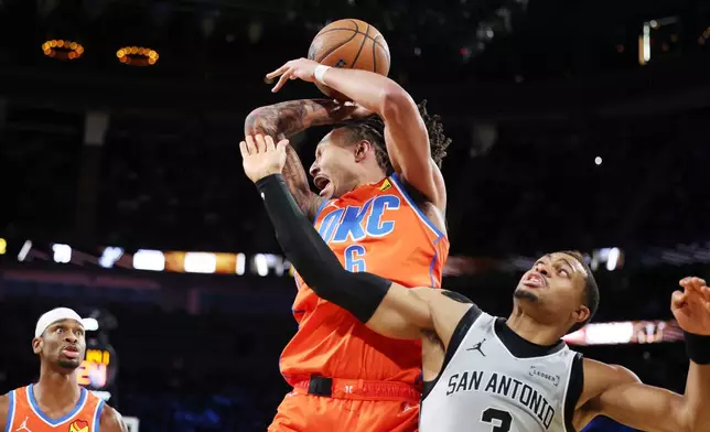 Oklahoma City Thunder forward Jaylin Williams (6) and San Antonio Spurs forward Keldon Johnson (3) collide while going for a rebound during the second half of an NBA Cup semifinals basketball game, Saturday, Dec. 13, 2025, in Las Vegas. (AP Photo/Ronda Churchill)