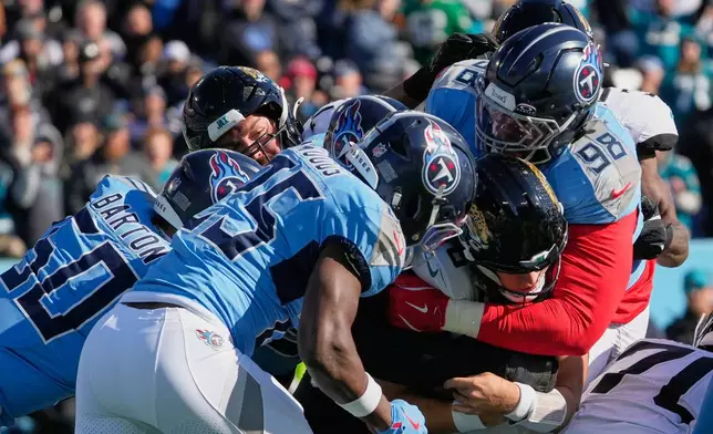 Jacksonville Jaguars quarterback Trevor Lawrence, center, pushes his way past the Tennessee Titans defense for a 2-point conversion during the first half of an NFL football game Sunday, Nov. 30, 2025, in Nashville, Tenn. (AP Photo/George Walker IV)