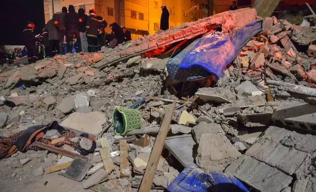 Rescue workers and residents search for survivors amid the wreckage of two collapsed buildings in Fez, Morocco, Tuesday, Dec. 9, 2025. (AP Photo/Ahmed Alaoui Mrani)