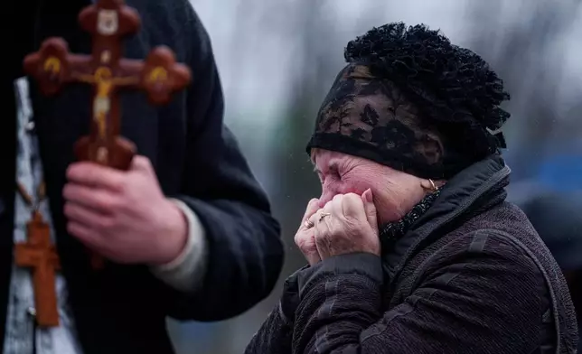 A mother cries in front of the coffin of her son Oleh Borovyk, a Ukrainian serviceman who was killed in fighting with Russian forces near Pokrovsk, during his funeral ceremony in Boiarka, Ukraine, on Wednesday, Dec. 3, 2025. (AP Photo/Evgeniy Maloletka)