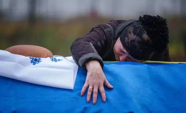 A mother cries at the coffin of her son Oleh Borovyk, a Ukrainian serviceman who was killed in fighting with Russian forces near Pokrovsk, during his funeral ceremony in Boiarka, Ukraine, on Wednesday, Dec. 3, 2025. (AP Photo/Evgeniy Maloletka)