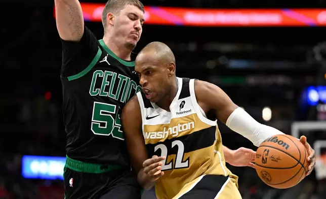 Washington Wizards forward Khris Middleton (22) drives to the basket against Boston Celtics guard Baylor Scheierman during the first half of an NBA basketball game Thursday, Dec. 4, 2025, in Washington. (AP Photo/John McDonnell)