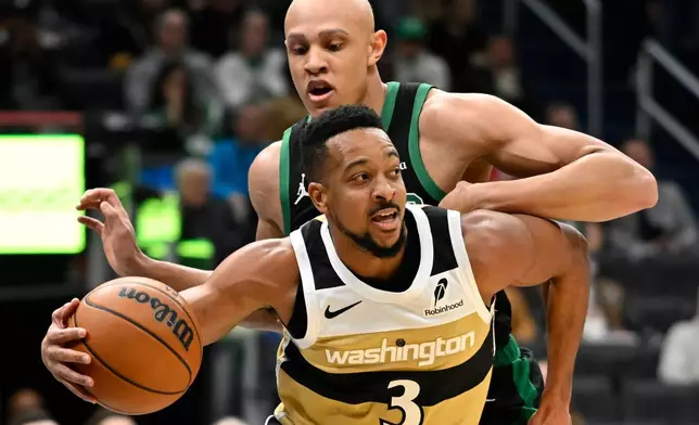 Washington Wizards guard CJ McCollum (3) dribbles past Boston Celtics guard Jordan Walsh to the basket during the first half of an NBA basketball game Thursday, Dec. 4, 2025, in Washington. (AP Photo/John McDonnell)