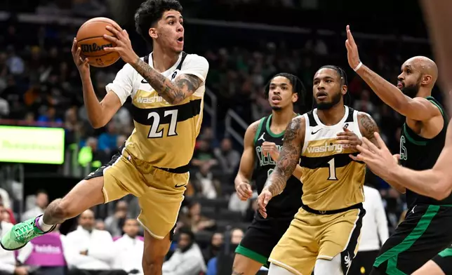 Washington Wizards guard Will Riley (27) looks to pass off under the basket during the first half of an NBA basketball game against the Boston Celtics Thursday, Dec. 4, 2025, in Washington. (AP Photo/John McDonnell)
