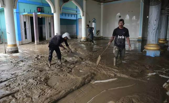 People clean up mud from a mosque at a village affected by the floods in Pidie Jaya, Aceh province, Indonesia, Wednesday, Dec. 3, 2025. (AP Photo/Reza Saifullah)