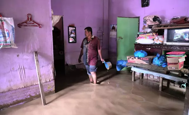 A man stands inside his flooded home in Pidie Jaya, Aceh province, Indonesia, Wednesday, Dec. 3, 2025. (AP Photo/Reza Saifullah)