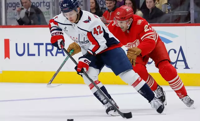 Washington Capitals defenseman Martin Fehervary (42) is pursued by Detroit Red Wings left wing James van Riemsdyk (21) during the first period of an NHL hockey game Sunday, Dec. 21, 2025, in Detroit. (AP Photo/Duane Burleson)