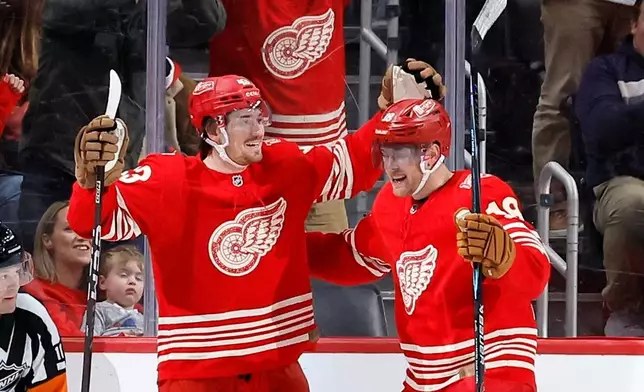 Detroit Red Wings left wing John Leonard, left, celebrates with center Andrew Copp (18) after scoring against the Washington Capitals during the second period of an NHL hockey game Sunday, Dec. 21, 2025, in Detroit. (AP Photo/Duane Burleson)