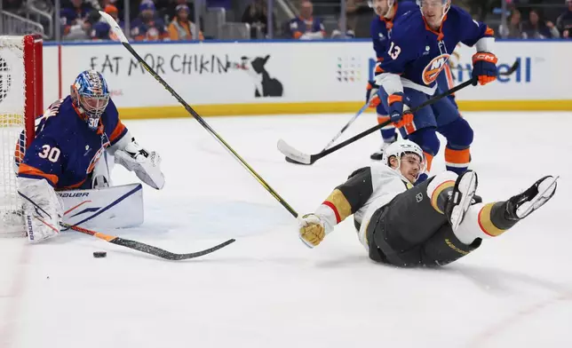New York Islanders goaltender Ilya Sorokin (30) is called for a penalty for tripping Vegas Golden Knights' Brett Howden, right, during the first period of an NHL hockey game, Tuesday, Dec. 9, 2025, in Elmont, N.Y. (AP Photo/Heather Khalifa)