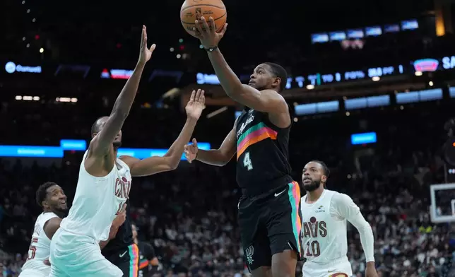 San Antonio Spurs guard De'Aaron Fox (4) drives to the basket abasing Cleveland Cavaliers center Evan Mobley (4) during the second half of an NBA basketball game in San Antonio, Monday, Dec. 29, 2025. (AP Photo/Eric Gay)