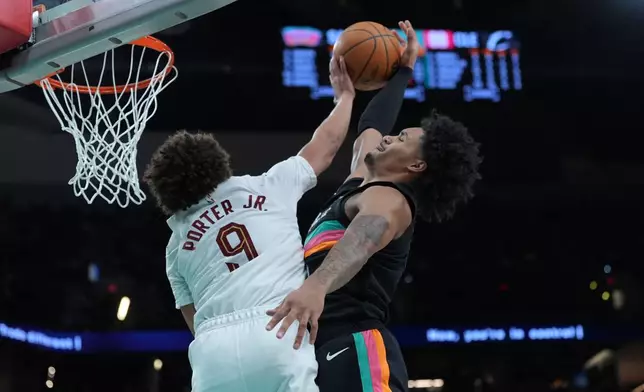 San Antonio Spurs guard Dylan Harper, right, is blocked by Cleveland Cavaliers guard Craig Porter Jr. (9) as he drives to the basket during the second half of an NBA basketball game in San Antonio, Monday, Dec. 29, 2025. (AP Photo/Eric Gay)