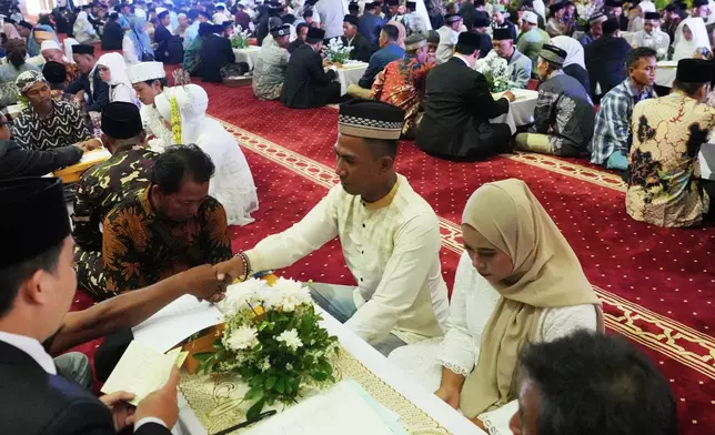 A couple gets married during a mass wedding ceremony at Istiqlal Mosque in Jakarta, Indonesia, Wednesday, Dec. 3, 2025. (AP Photo/Tatan Syuflana)