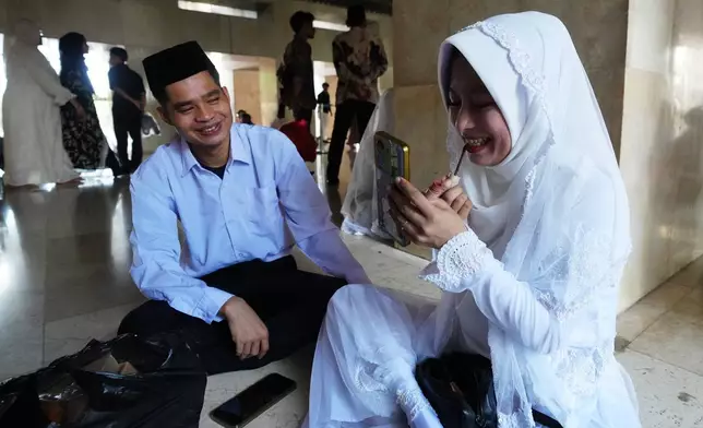 A couple prepare for a mass wedding ceremony at Istiqlal Mosque in Jakarta, Indonesia, Wednesday, Dec. 3, 2025. (AP Photo/Tatan Syuflana)