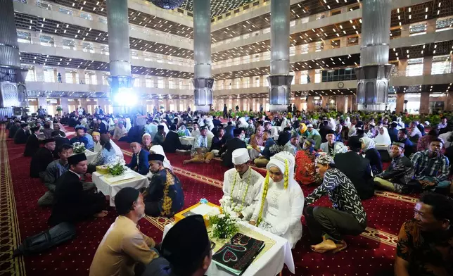 Brides and grooms prepare for a mass wedding ceremony at Istiqlal Mosque in Jakarta, Indonesia, Wednesday, Dec. 3, 2025. (AP Photo/Tatan Syuflana)