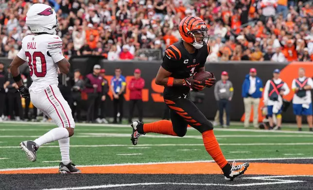 Cincinnati Bengals wide receiver Ja'Marr Chase, right, scores a touchdown during the first half of an NFL football game against the Arizona Cardinals, Sunday, Dec. 28, 2025, in Cincinnati. (AP Photo/Jeff Dean)