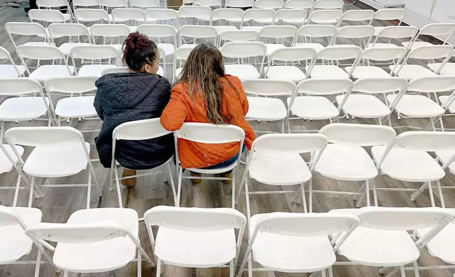 Two women listen during an informational meeting held by the Nebraska Department of Labor for Tyson Foods employees in Lexington, Neb., Thursday, Dec. 4, 2025. (AP Photo/Thomas Peipert)