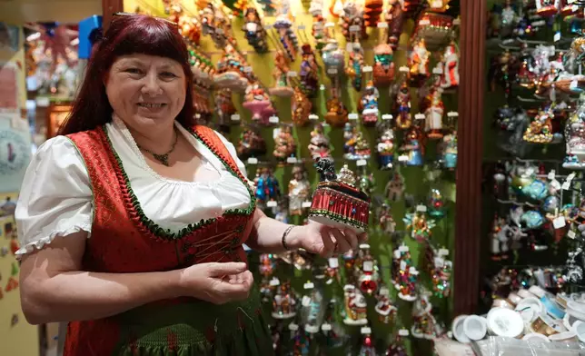 Owner of the Christel Dauwe Collection ornaments shop, Christel Dauwe, shows an ornament of the Horse Bayard, a folkloric Belgian event, at her shop in Antwerp, Belgium, Monday, Dec. 8, 2025. (AP Photo/Virginia Mayo)
