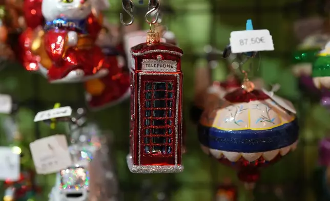 A holiday ornament of a British phone cabin hangs on a shelf in the Christel Dauwe Collection ornaments shop in Antwerp, Belgium, Monday, Dec. 8, 2025. (AP Photo/Virginia Mayo)