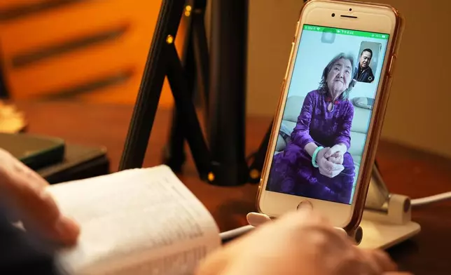 Former Chinese official Li Chuanliang reads the Bible to his elderly mother Shen Shuzi back in China over a video call, in Midland, Texas, Jan. 18, 2025. (AP Photo/Rebecca Blackwell)