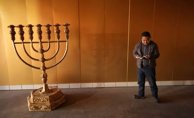 Former Chinese official Li Chuanliang holds a Bible as he prays inside the Mayflower Church temple sanctuary in Midland, Texas, Jan. 18, 2025. (AP Photo/Rebecca Blackwell)