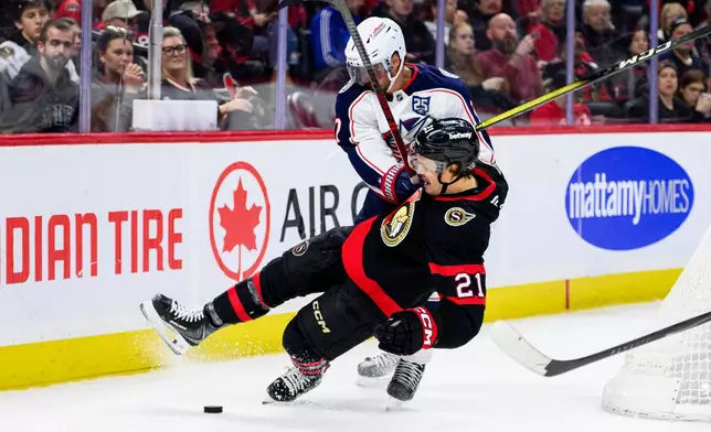 Columbus Blue Jackets' Brendan Smith (7) checks Ottawa Senators' Nick Cousins (21) during second period NHL hockey action in Ottawa on Monday, Dec. 29, 2025. (Spencer Colby/The Canadian Press via AP)