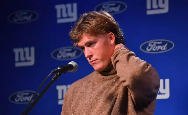 New York Giants quarterback Jaxson Dart reacts during a news conference while talking to the media after a loss to the New England Patriots in an NFL football game Monday, Dec. 1, 2025, in Foxborough, Mass. (AP Photo/Steven Senne)