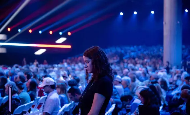 An attendee prays during Turning Point USA's AmericaFest 2025, Thursday, Dec. 18, 2025, in Phoenix. (AP Photo/Jon Cherry)