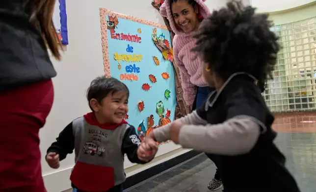 Flor Perez encourages her class of 2-year-olds in a walk around the school in lieu of outdoor walks around the neighborhood during school time at CentroNia in Washington, Tuesday, Dec. 9, 2025. (AP Photo/Jacquelyn Martin)