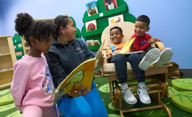 Celenia Romero reads to her Prek-5 students in the library at CentroNia in Washington, Tuesday, Dec. 9, 2025. (AP Photo/Jacquelyn Martin)