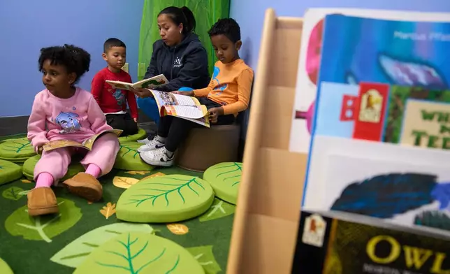 Celenia Romero reads to her Prek-5 students in the library at CentroNia in Washington, Tuesday, Dec. 9, 2025. (AP Photo/Jacquelyn Martin)
