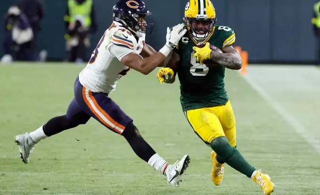 Green Bay Packers running back Josh Jacobs (8) runs against Chicago Bears linebacker D'Marco Jackson, left, during the second half of an NFL football game Sunday, Dec. 7, 2025, in Green Bay, Wis. (AP Photo/Mike Roemer)